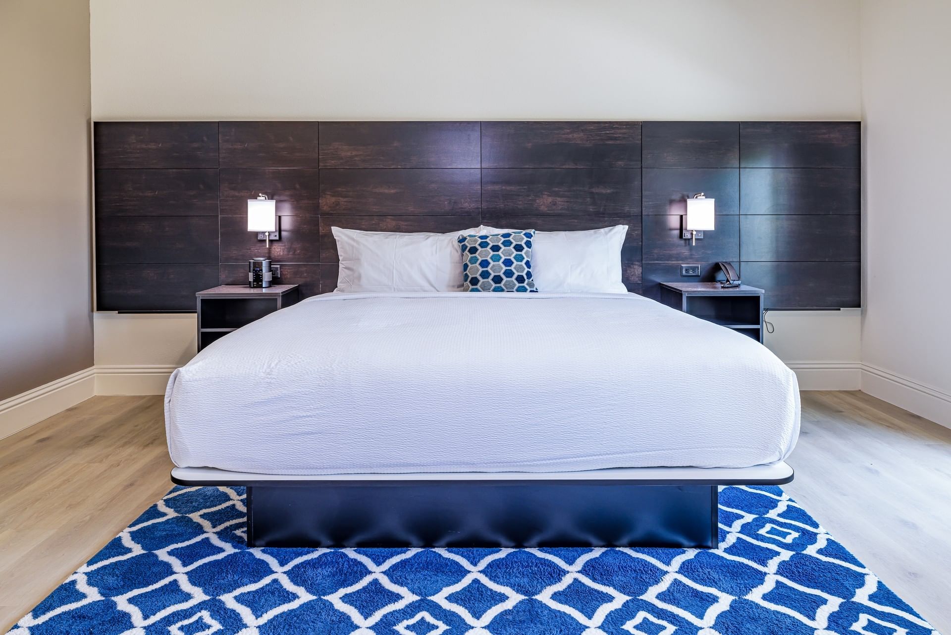 King room with white bedding and navy patterned rug