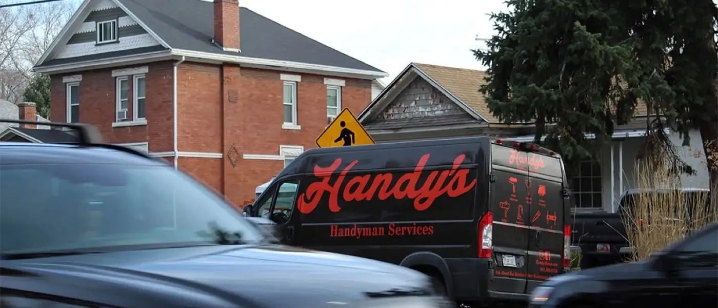 The Handy's van parked on a Salt Lake City street in late fall, bare trees behind a brick house