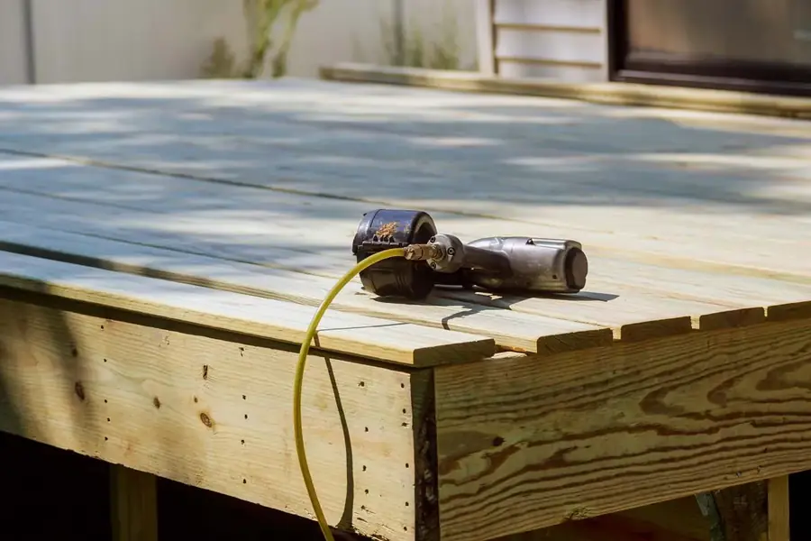 A freshly repaired wooden deck with a drill resting on the boards